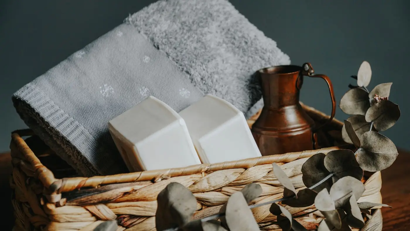 Panier d'accueil avec serviette pliée, savons et branches d'eucalyptus
